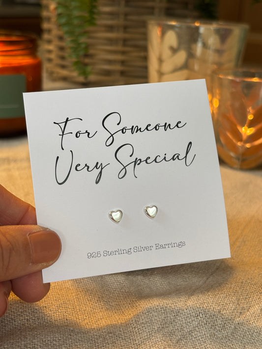 Heart-shaped earrings on a card with 'For Someone Very Special' text, held by a hand.